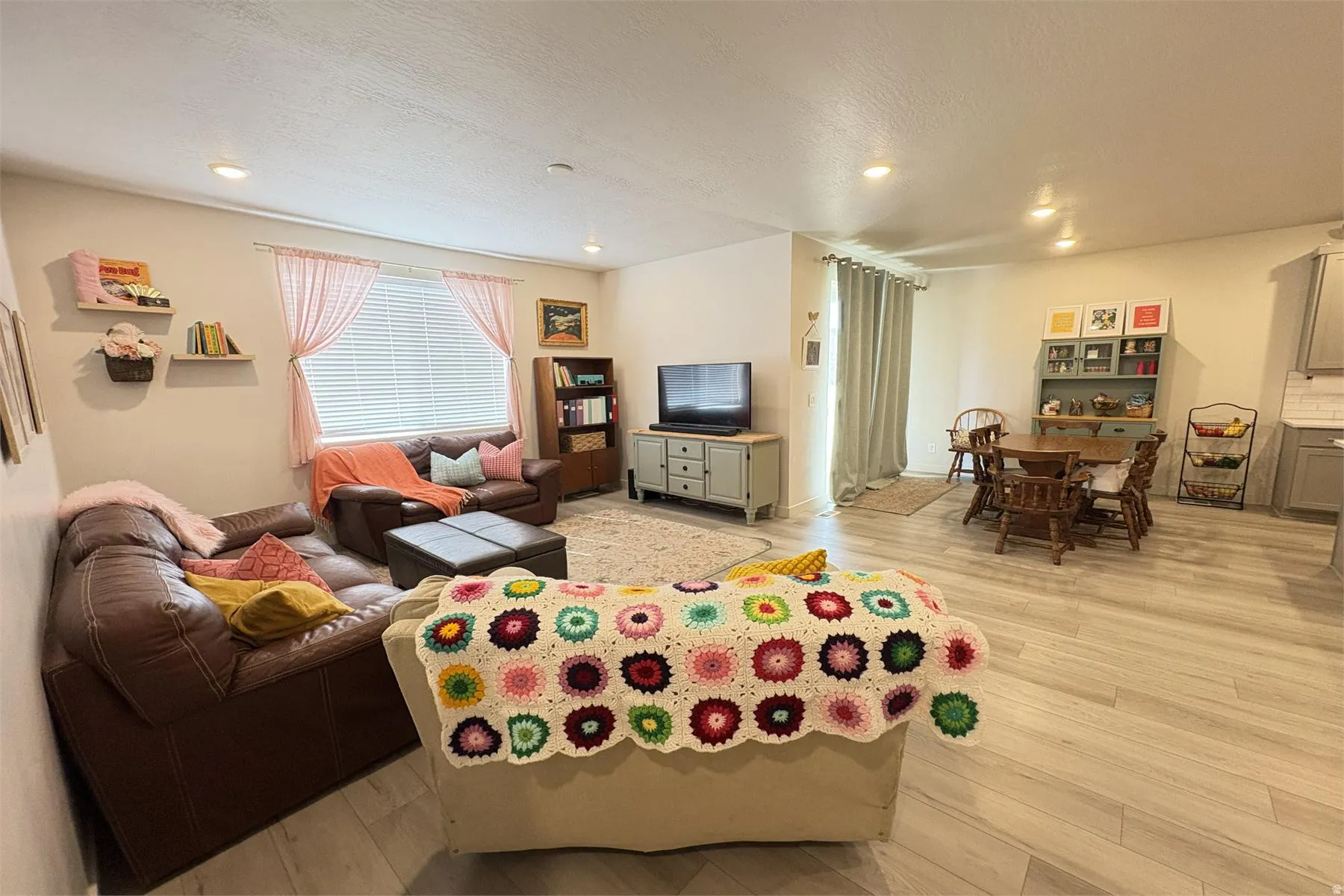 Open-concept living area featuring recessed lighting, wood-finish flooring, and window blinds