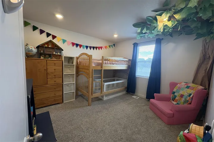Carpeted room featuring a window with blinds and drapes, recessed lighting, and a sloped ceiling