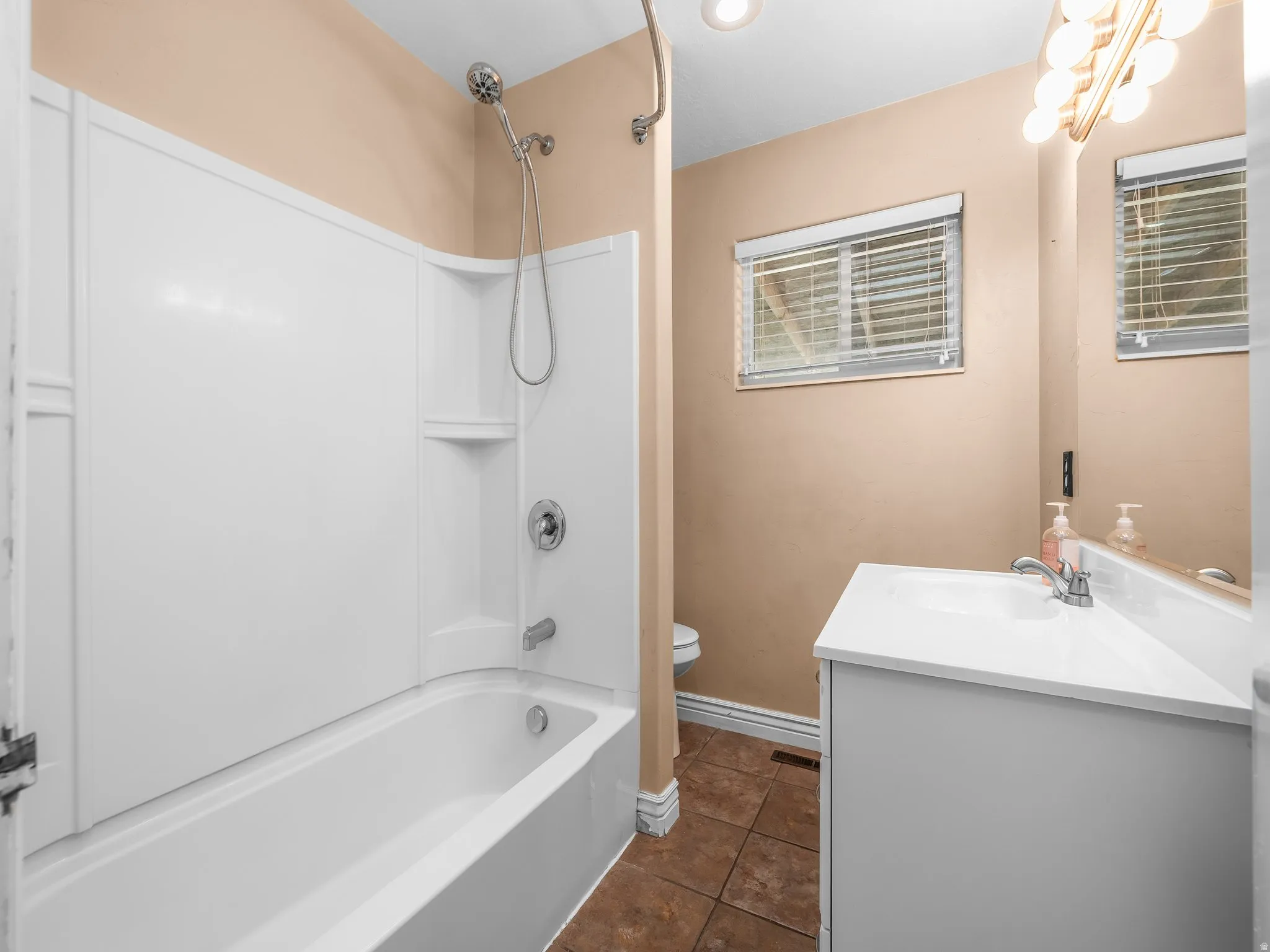 Upstairs guest bathroom. Bathtub with integrated shower, white vanity with integrated sink, chrome fixtures, and a window with horizontal blinds