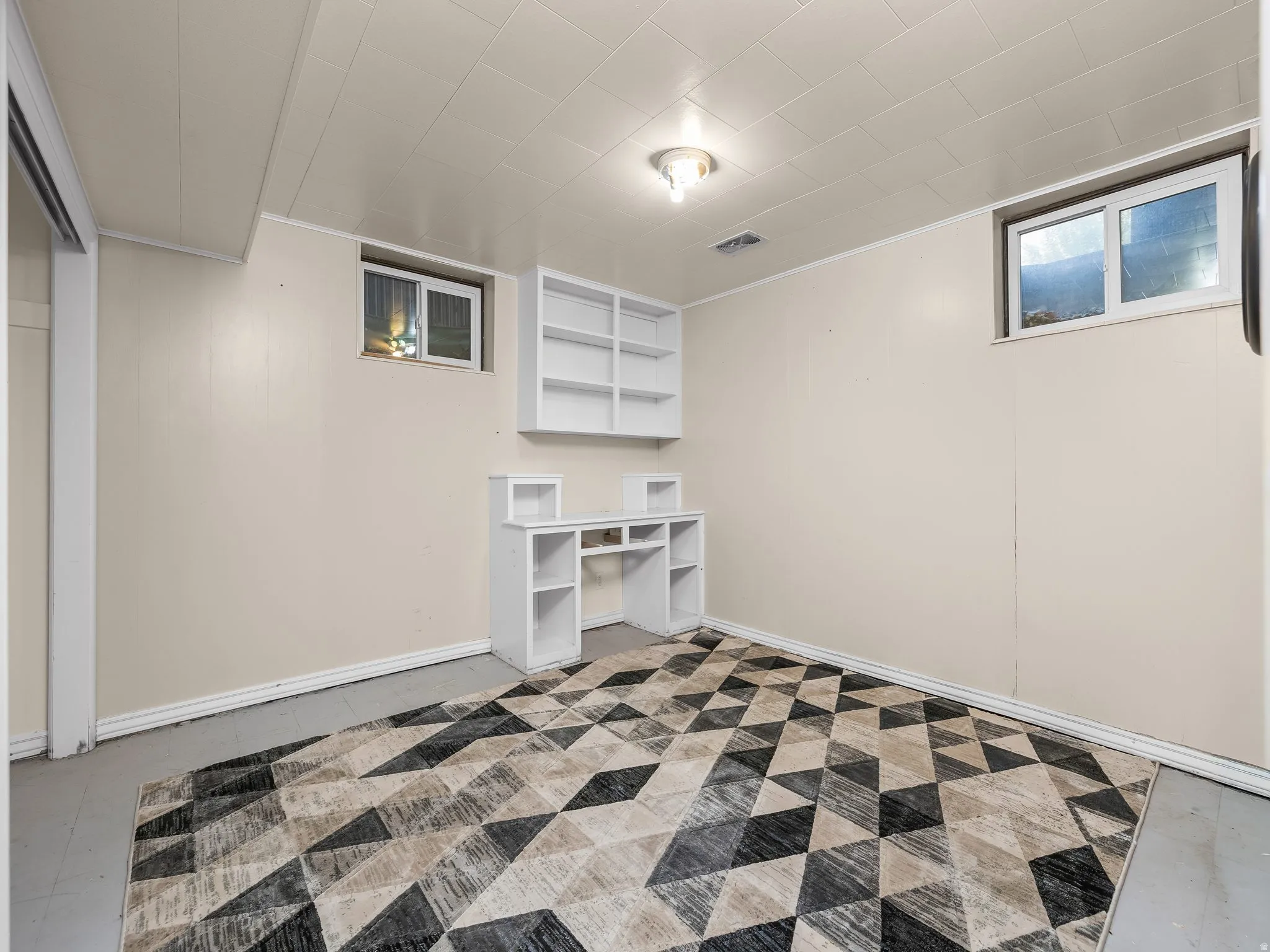 Bedroom 2. Built-in shelving unit, dedicated desk space, recessed window, and flush-mount ceiling light