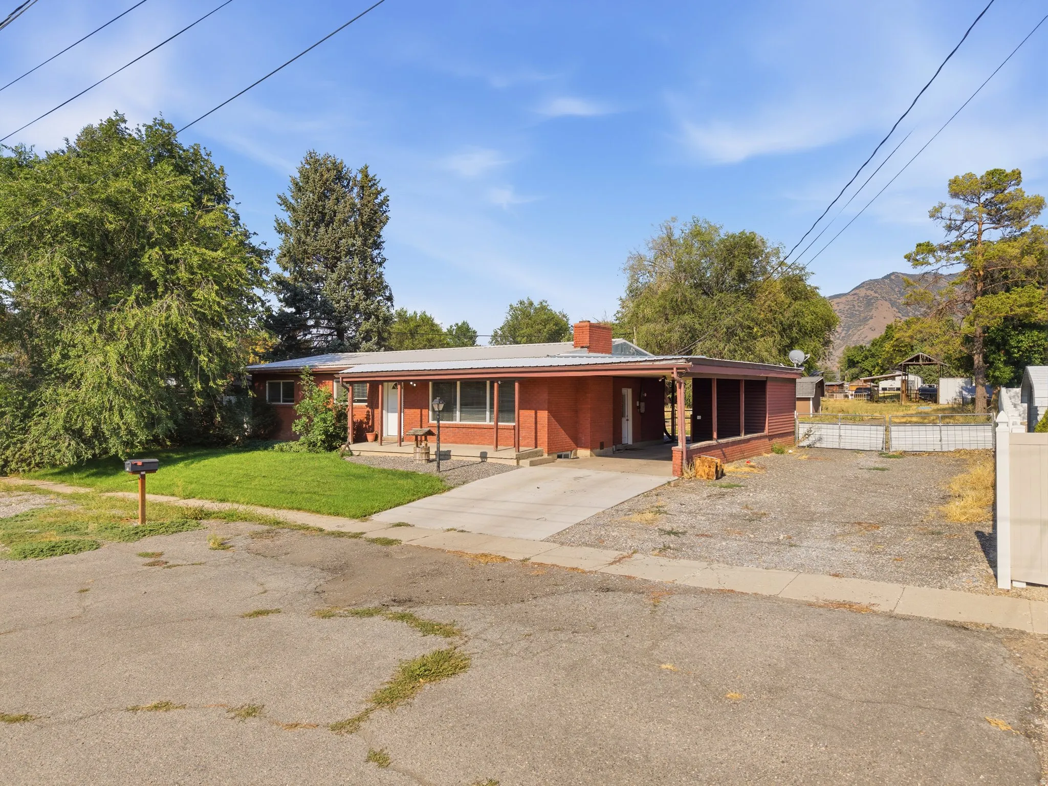 RV wide parking, with gate access to the backyard. Brick exterior, covered porch, carport, concrete driveway, front lawn