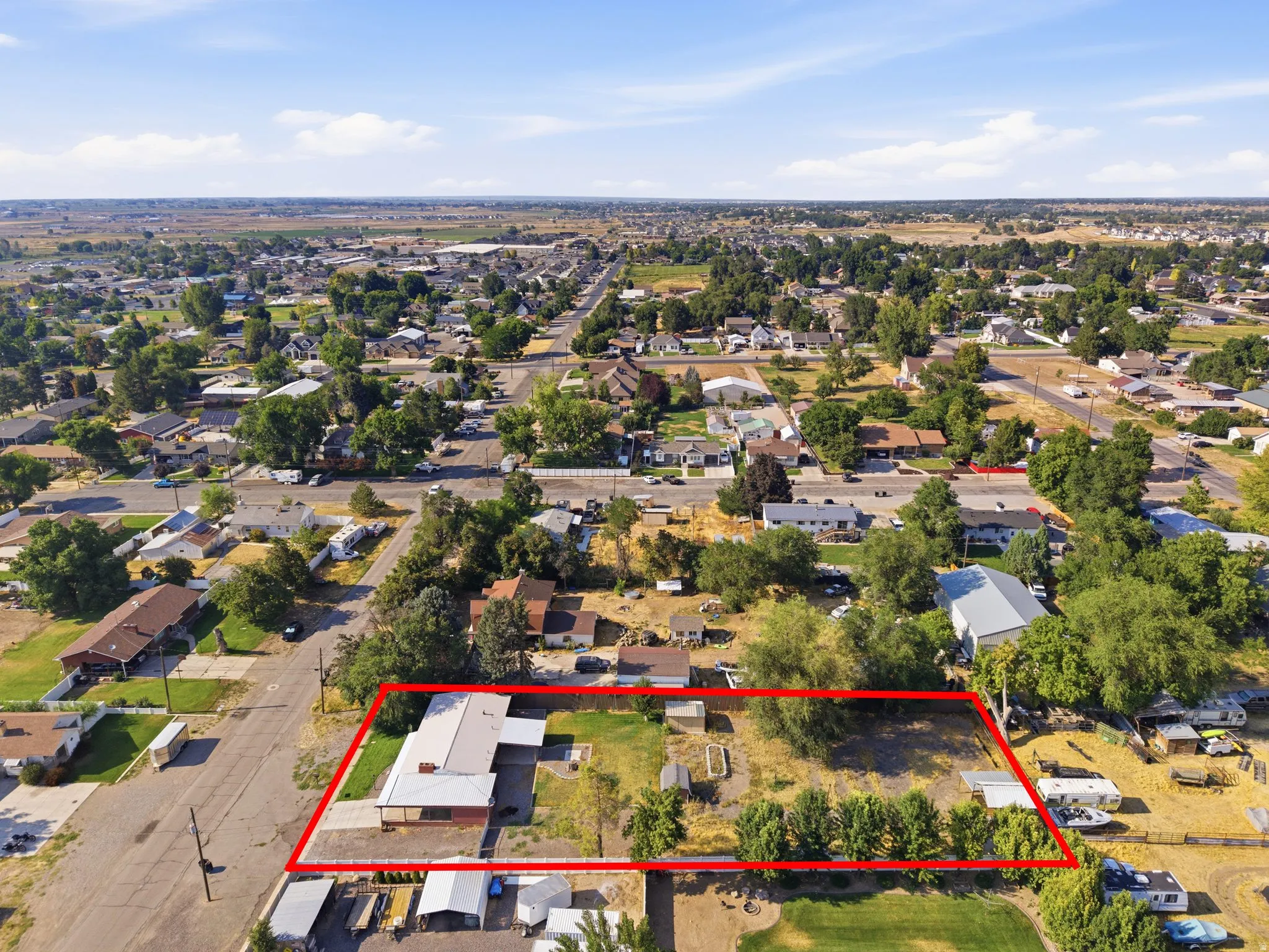 Property lines. Expansive lot with mature trees and open land, situated in a developed neighborhood with surrounding residences and infrastructure