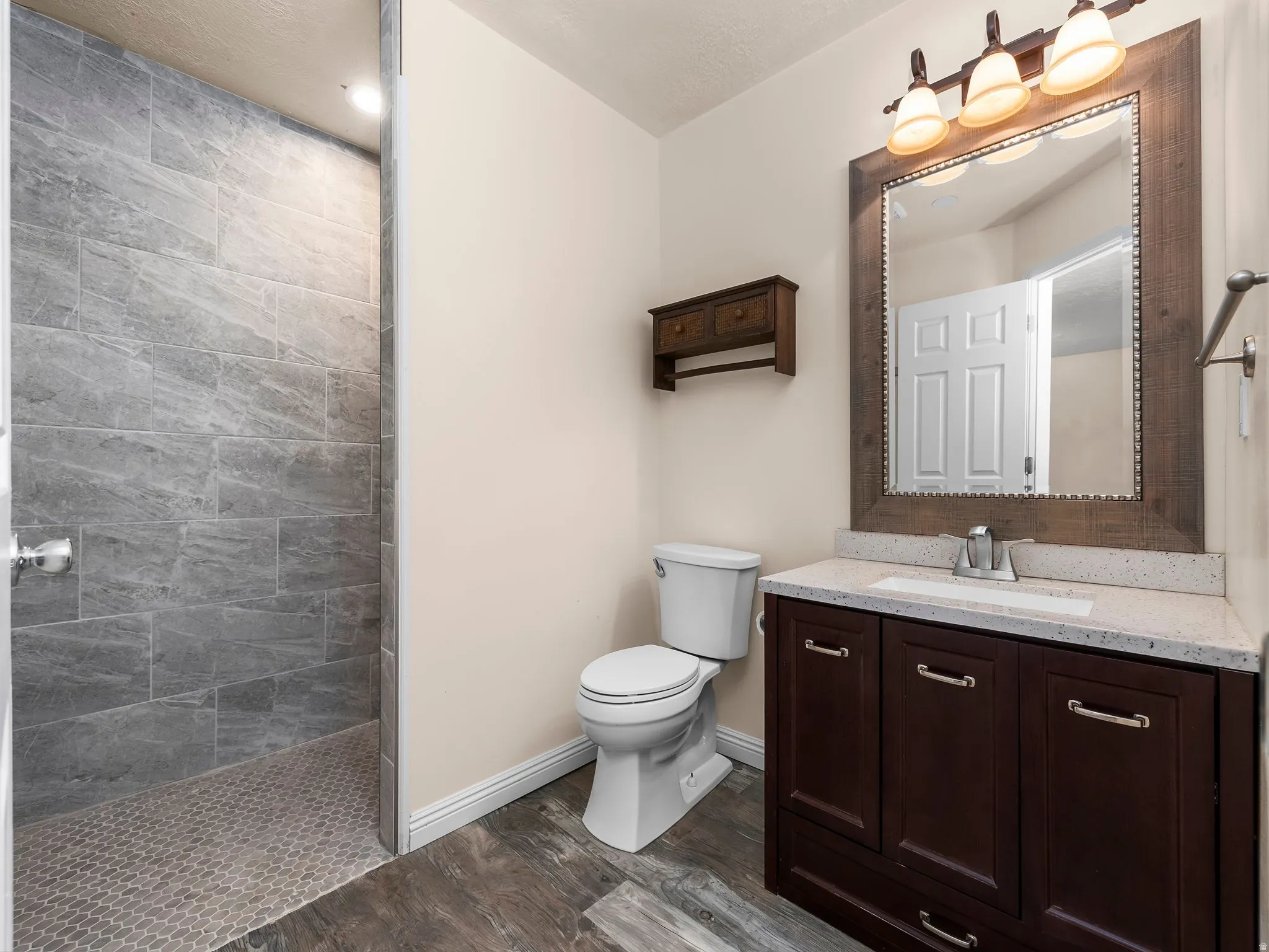 Primary bedroom en-suite bathroom. Walk-in shower with large-format wall tiles and hex mosaic floor