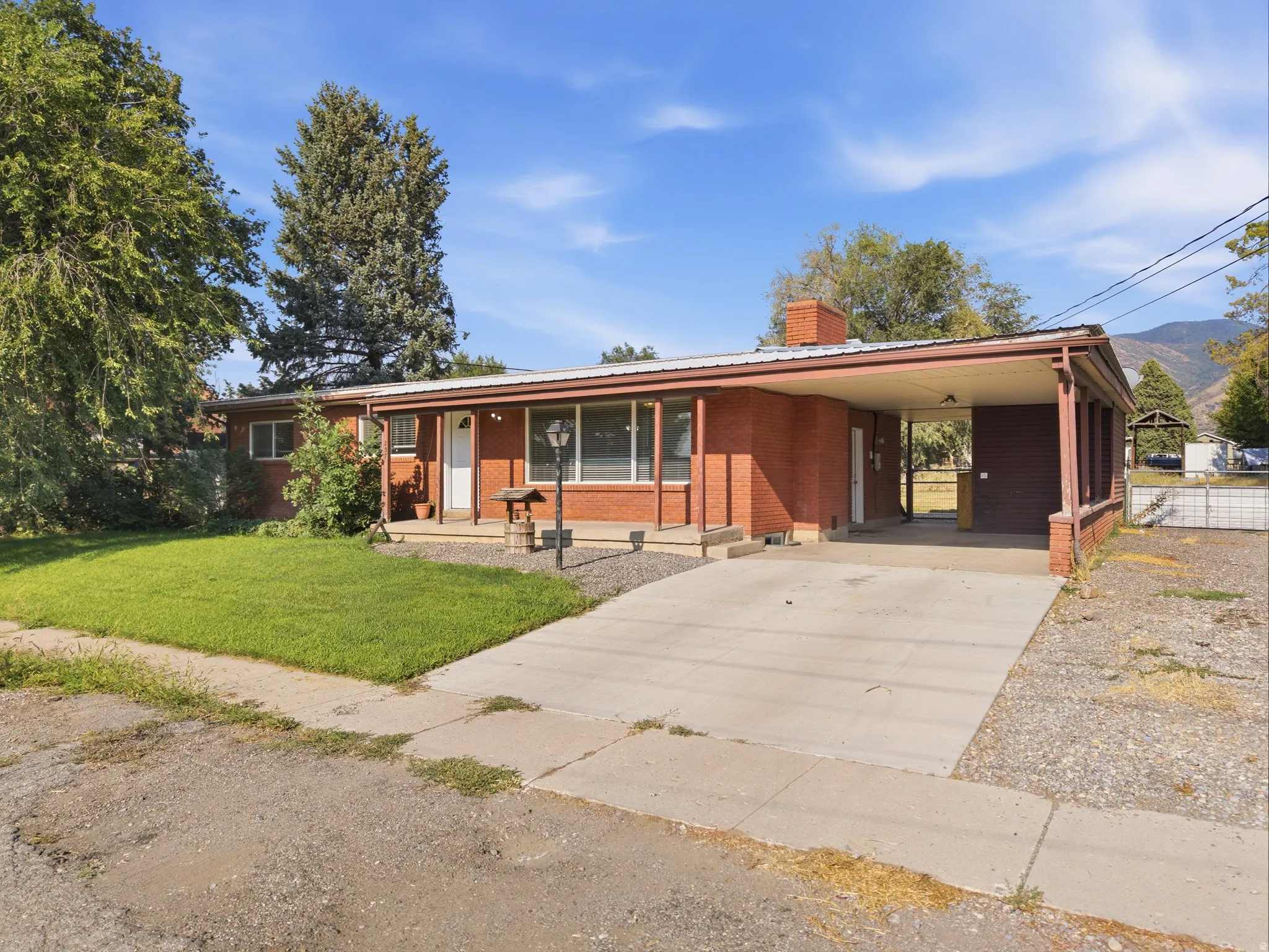 Tandem driveway with storage unit. Brick exterior with a covered carport