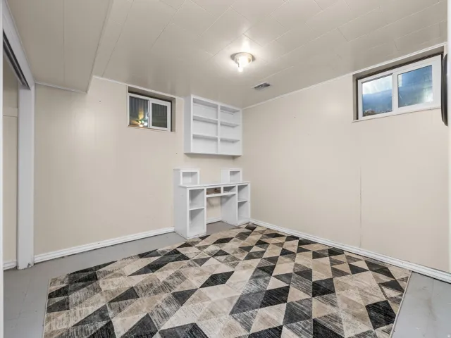 Bedroom 2. Built-in shelving unit, dedicated desk space, recessed window, and flush-mount ceiling light