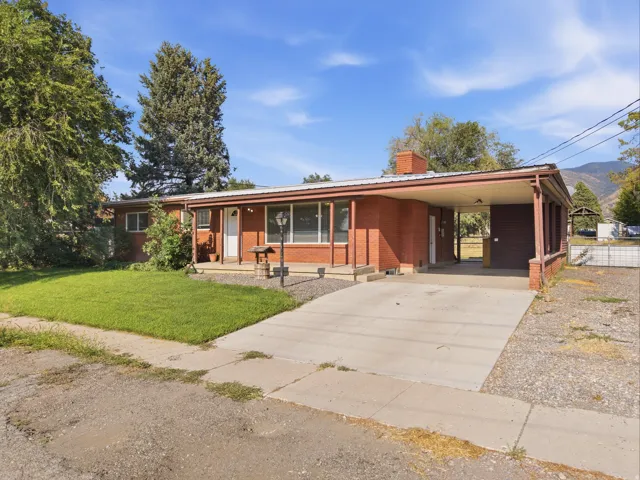 Tandem driveway with storage unit. Brick exterior with a covered carport