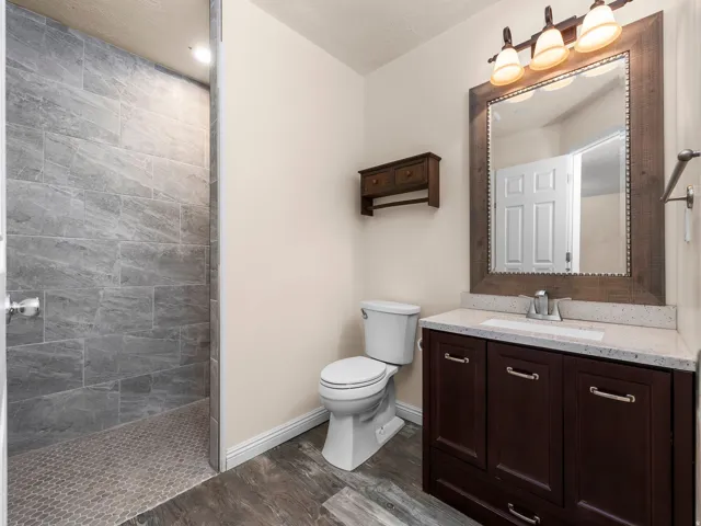 Primary bedroom en-suite bathroom. Walk-in shower with large-format wall tiles and hex mosaic floor