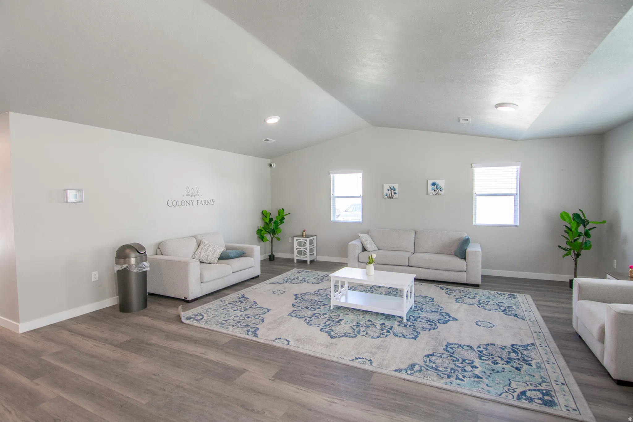 Spacious common area featuring vaulted ceilings, wood-finish flooring, recessed lighting, and multiple windows with blinds