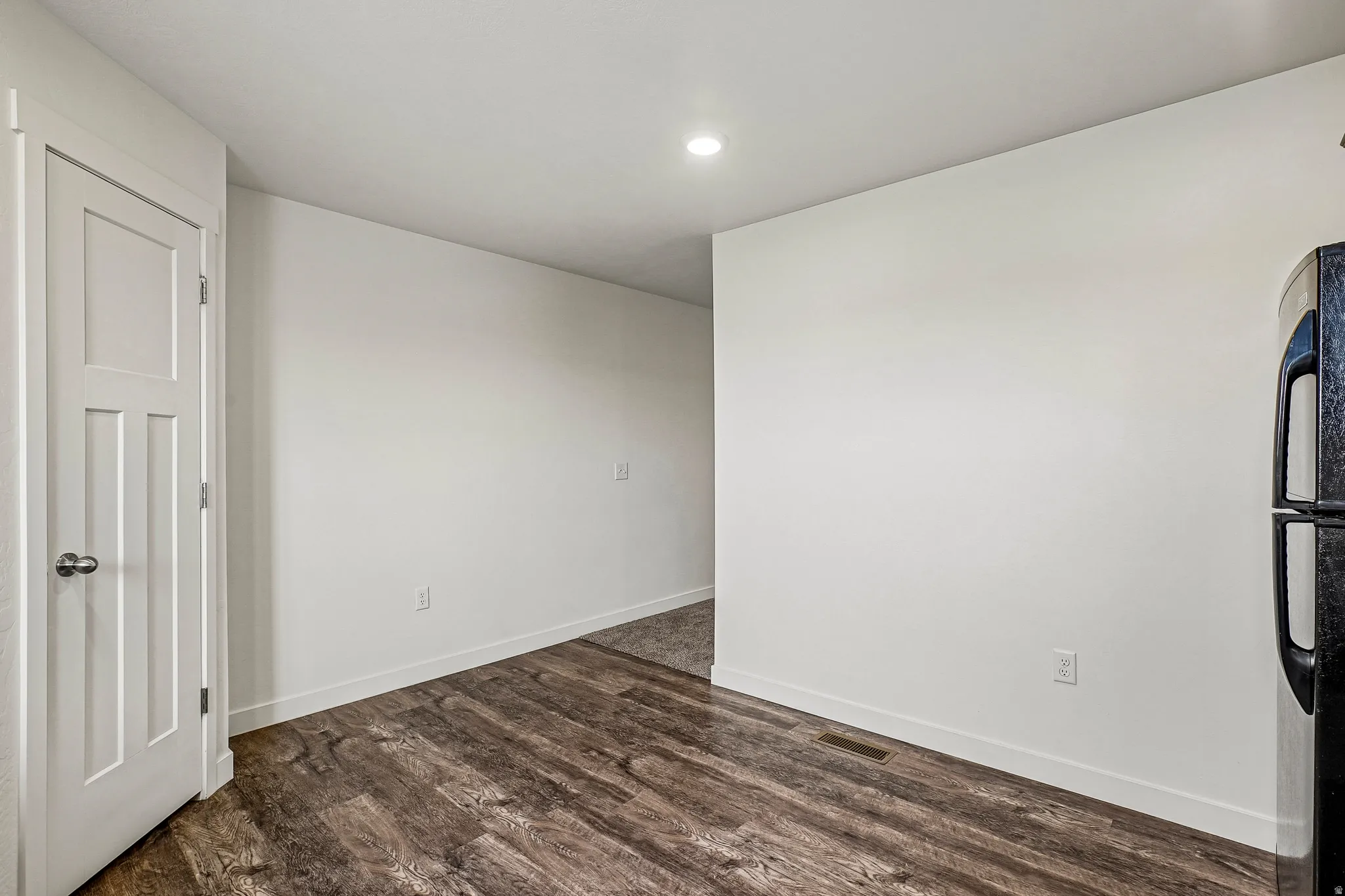 Wide plank wood-finish flooring complements crisp white walls