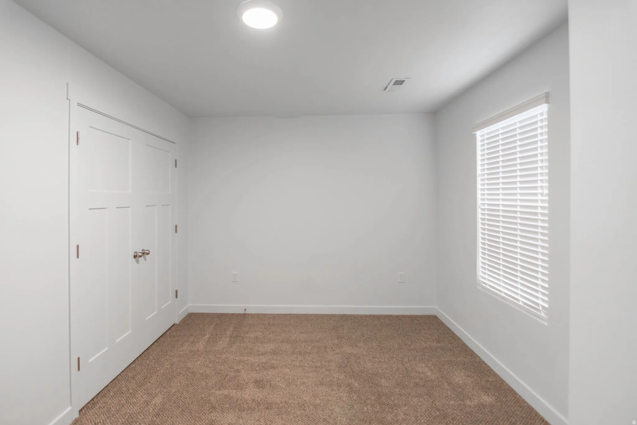 Neutral wall tones with plush carpeting and ample natural light