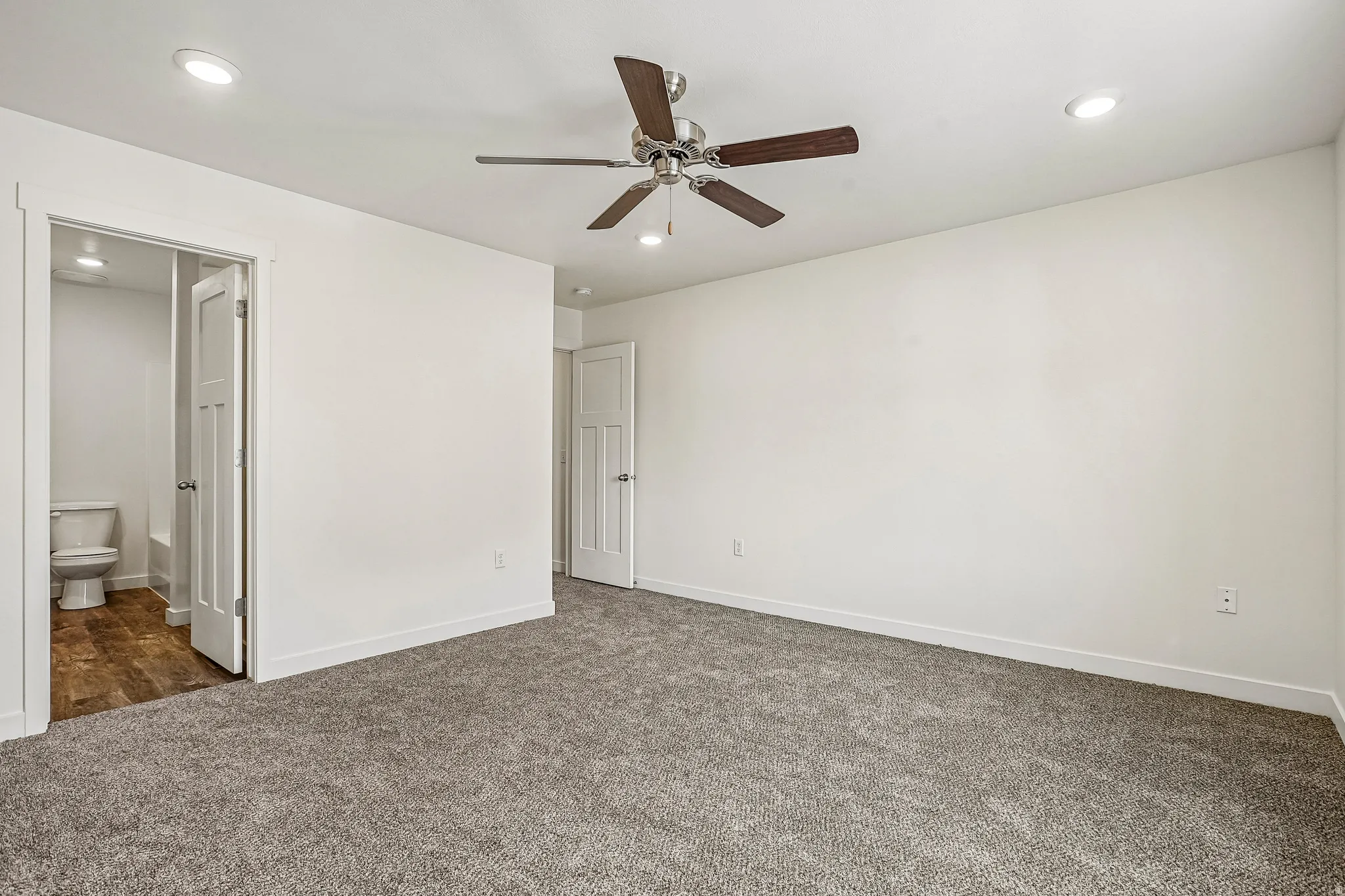 Spacious room featuring gray carpet flooring and white walls