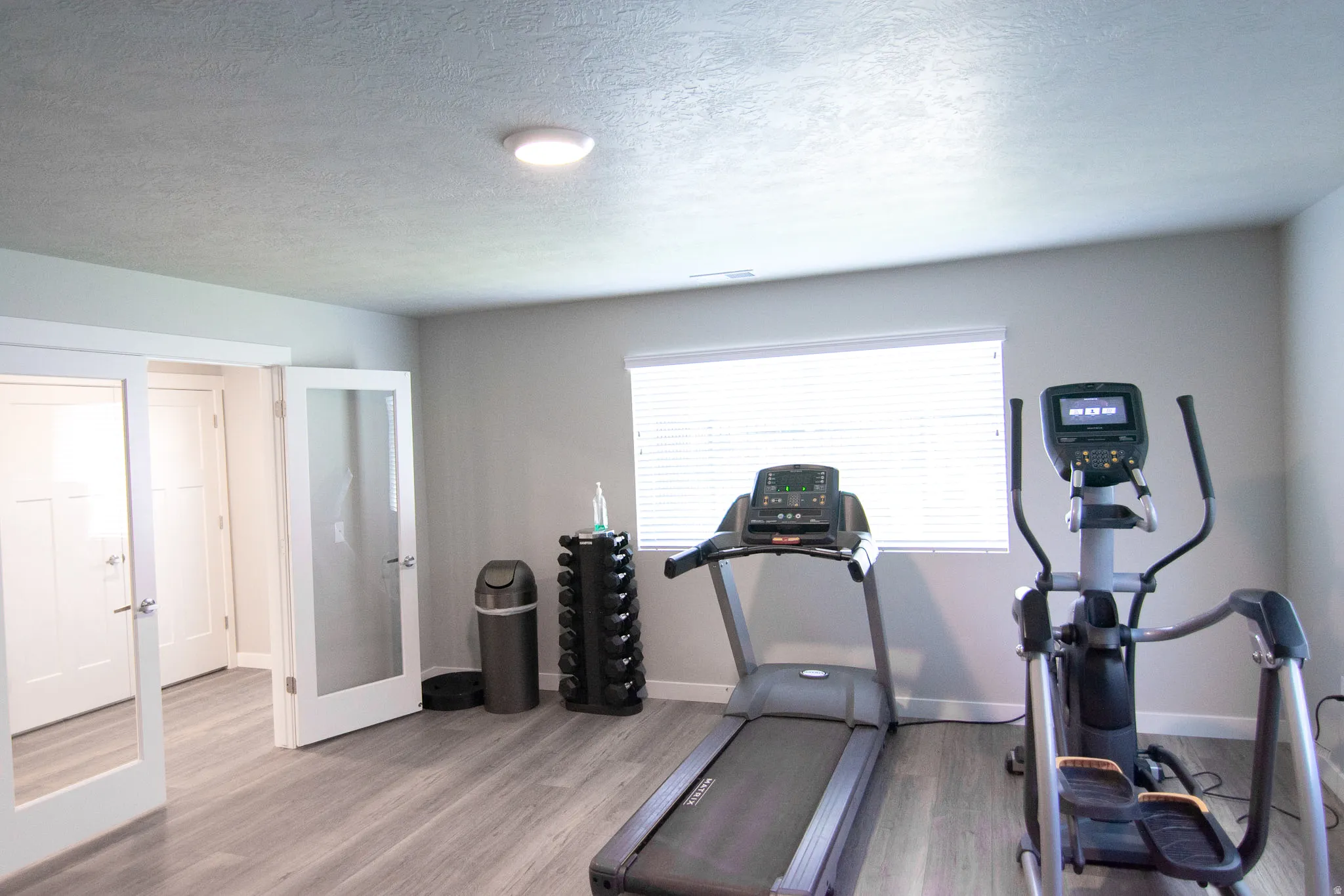 Versatile interior space featuring wood-finish flooring, neutral wall tones, and recessed lighting