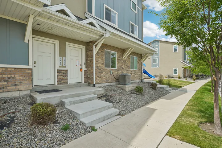 Modern townhome exterior featuring light brick, blue siding, and white trim
