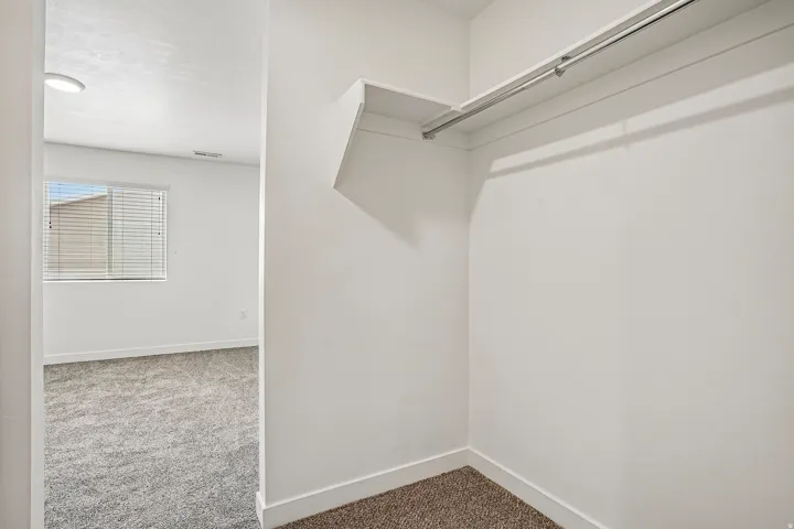 Walk-in closet featuring a built-in shelf and hanging rod