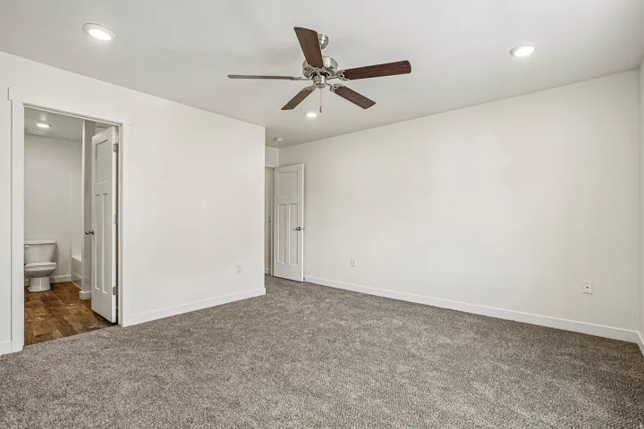 Spacious room featuring gray carpet flooring and white walls