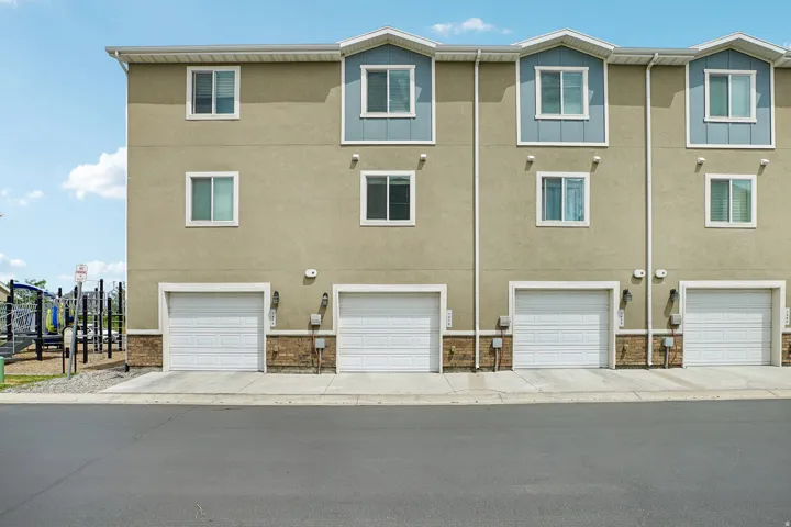 Multi-story townhome exterior featuring individual garage access