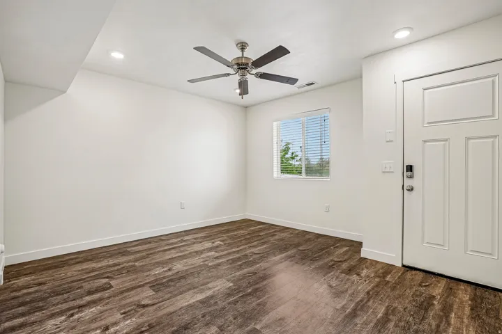 Interior space featuring wood-finish flooring, white baseboards, and bright white walls