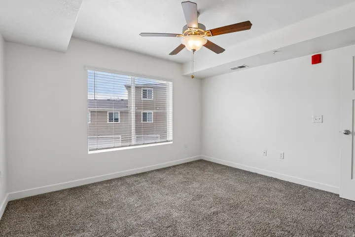 Room featuring neutral-toned carpet flooring and a ceiling fan with integrated lighting