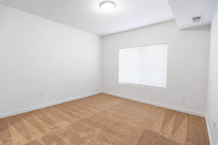 Interior room featuring light-colored walls and tan carpeting