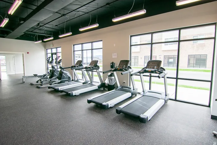 Spacious fitness center featuring a rubberized floor and a selection of cardio equipment