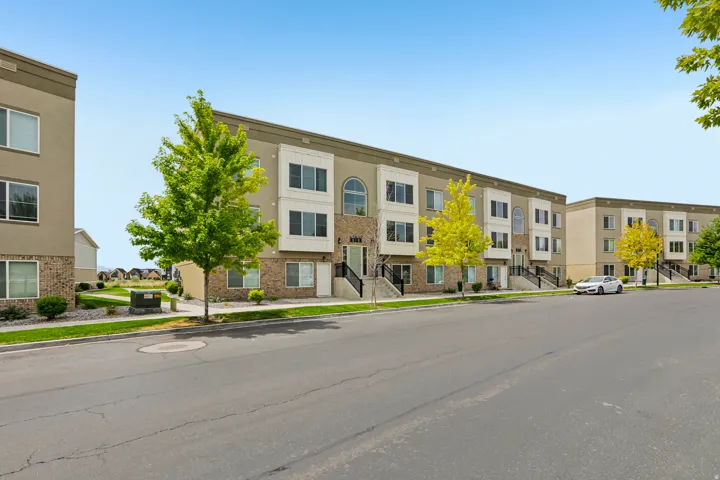 Contemporary townhome-style residences featuring multi-level facades with light stucco and brick accents