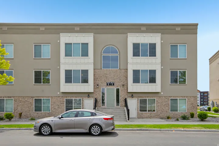 Modern multi-story building featuring a stucco and brick facade with white trim accents