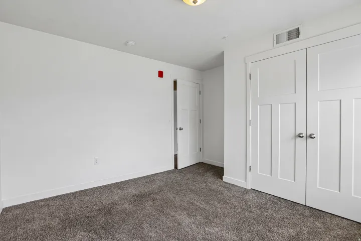 Bedroom featuring neutral carpeting, white walls, and bright white trim