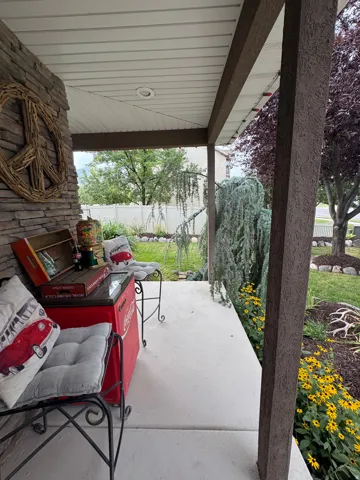 Covered porch featuring a stone-clad pillar, recessed lighting, and a concrete floor