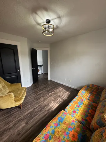Wood-finish flooring with light wall tones and a modern ceiling light fixture