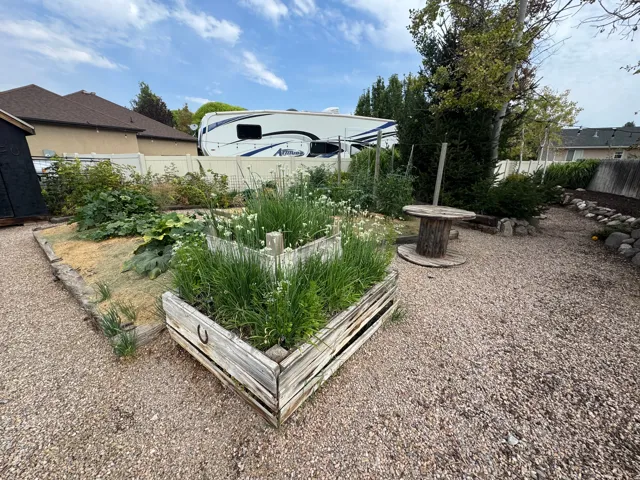 Gravel landscaping with a raised garden bed and established greenery
