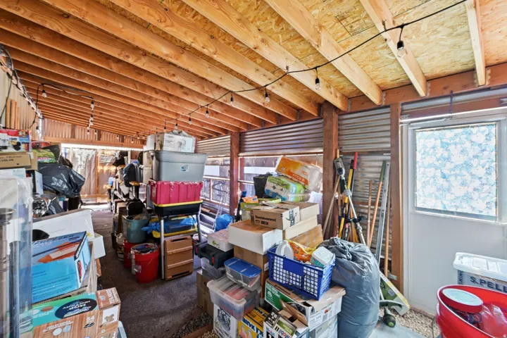 Exposed wood beam ceiling, corrugated metal siding, and a framed window
