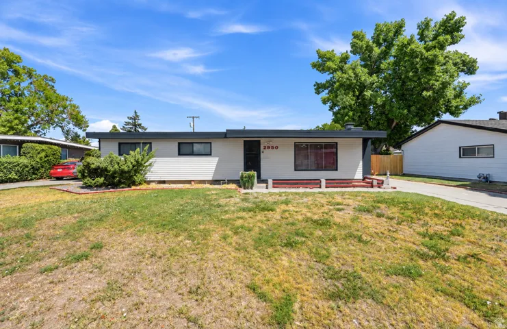 Fresh new paint! Single-story residence with a flat roofline, white siding, and dark trim