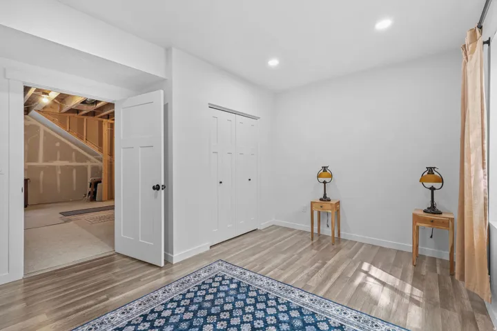 Wood-finish flooring, recessed lighting, and a white bi-fold closet door