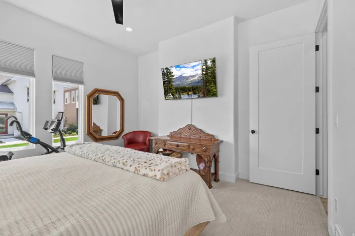 Recessed lighting, ceiling fan, carpeted flooring, white interior door with black hardware, and two large windows with blinds
