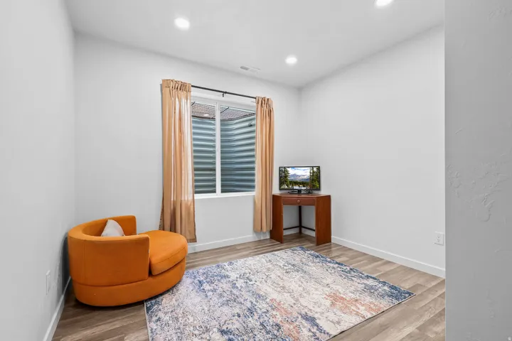 Recessed lighting, wood-finish flooring, and white walls