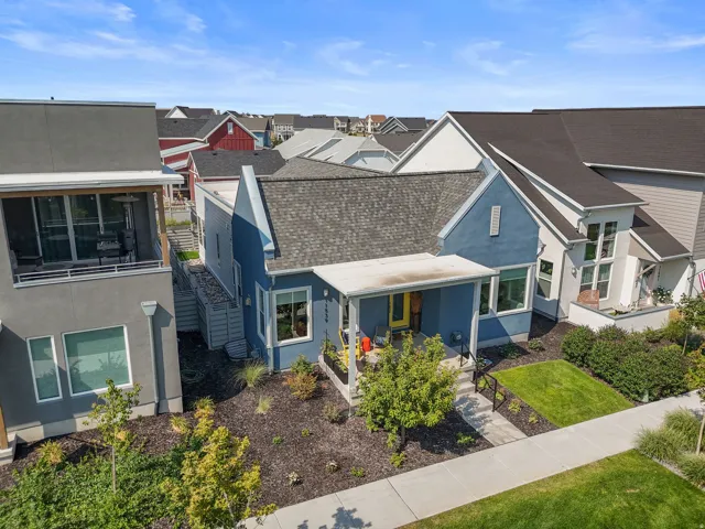 Exterior featuring a covered front porch, a well-maintained lawn, and established landscaping