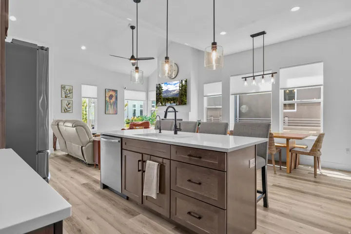 Kitchen island with light-toned countertop, integrated sink, and dark wood-finish cabinetry