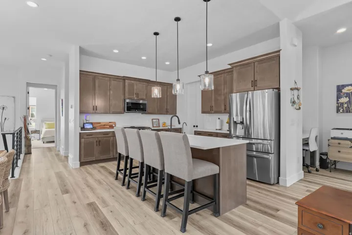 Kitchen featuring wood-finish flooring, recessed lighting, and a white countertop island with pendant lighting