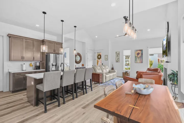 Vaulted ceilings, wood-finish flooring, recessed lighting, and a kitchen island with seating