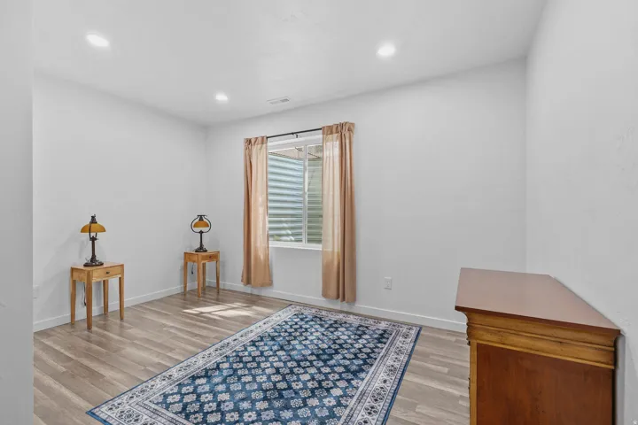 Recessed lighting illuminates neutral walls and wood-finish flooring