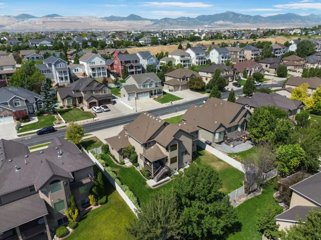 Expansive suburban residential area with diverse architectural styles, mature landscaping, and mountain scenery.
