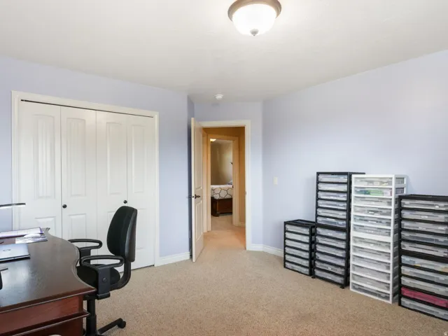 Additional bedroom 3, used as home office/craft room. Carpeted flooring, bi-fold closet doors, wall-mounted ceiling light fixture, neutral wall paint