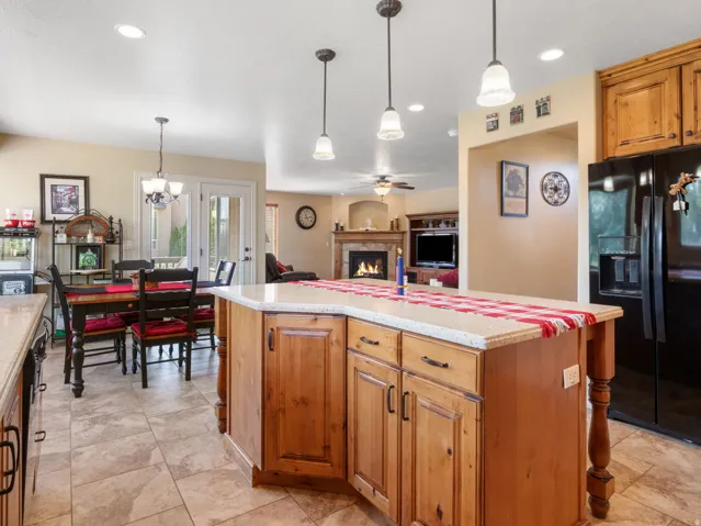 Large Kitchen featuring a large island with stone-finish countertops, wood cabinetry, and pendant lighting