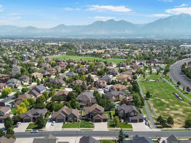 Residential neighborhood showing park with popular splash pad. Mature landscaping, and mountain scenery.