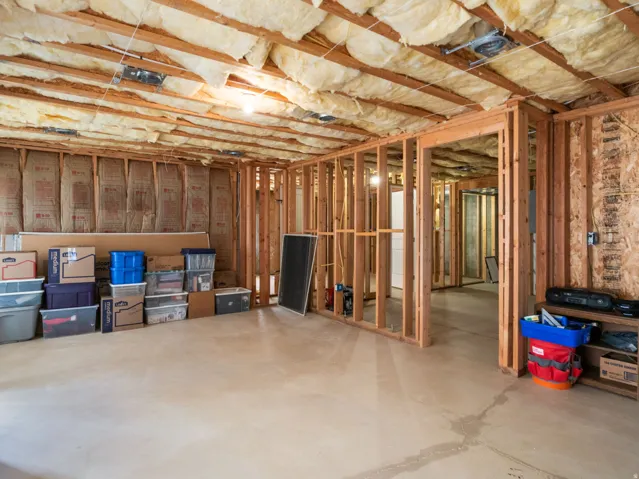 Unfinished basement with exposed wooden framing and concrete flooring