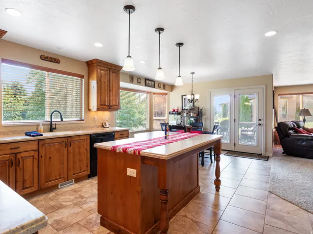 Large Kitchen featuring wood cabinetry, light-toned countertops, a central island, and tile flooring