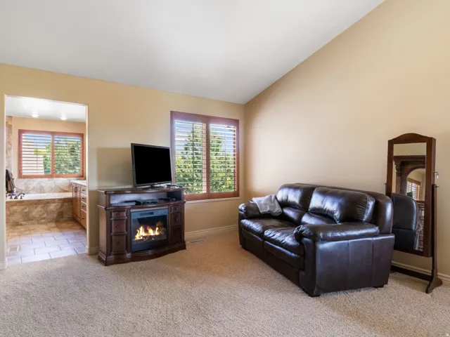 Primary Bedroom. Vaulted ceiling, two windows with plantation shutters, plush carpeting, separate bathroom en-suite.