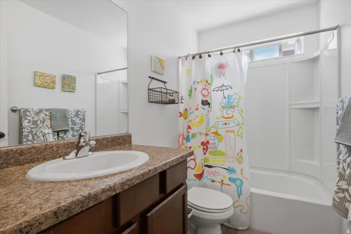 Bathroom featuring a vanity with an integrated sink, a laminate countertop, and a built-in mirror