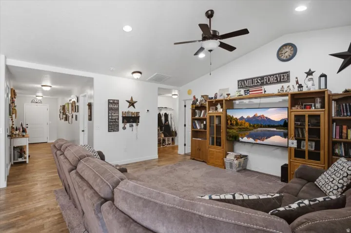 Vaulted ceiling with recessed lighting and a ceiling fan