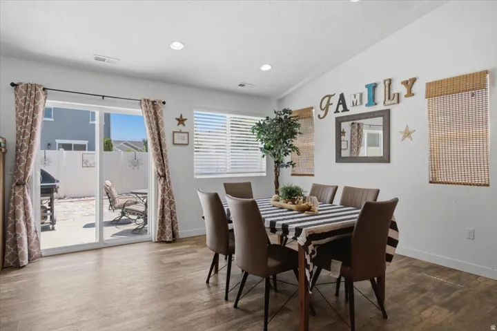Dining area featuring wood-finish flooring, vaulted ceilings, and recessed lighting